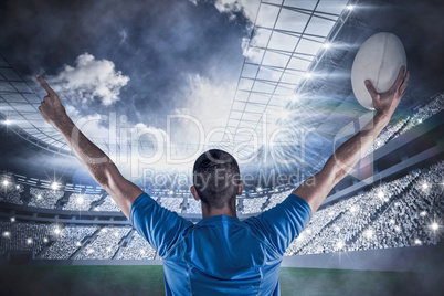 Composite image of rear view of rugby player holding ball with a