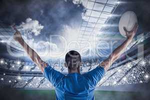 Composite image of rear view of rugby player holding ball with a