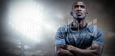 Composite image of thoughtful athlete standing with arms crossed