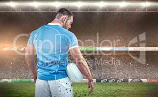 Composite image of rugby player standing with ball