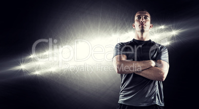 Composite image of confident rugby player with arms crossed