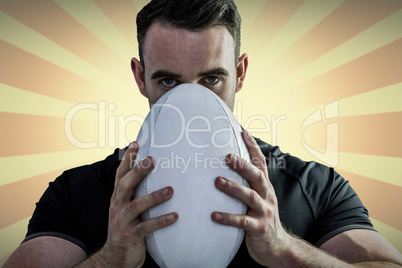 Composite image of tough rugby player holding ball