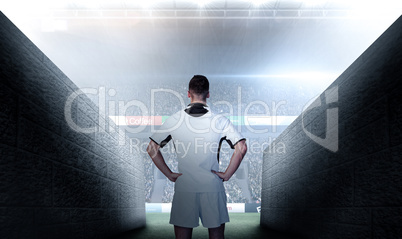 Composite image of rear view of a rugby player with hands on wai