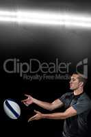 Composite image of rugby player catching ball