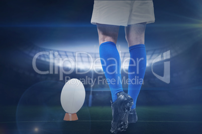 Composite image of low section of rugby player going to kick the ball