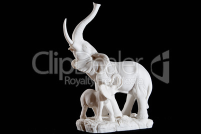 Classic white marble statuette of elephant with elephant calf isolated on black background