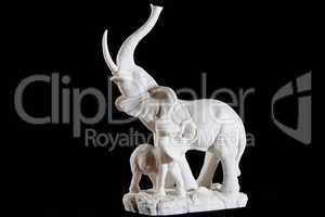 Classic white marble statuette of elephant with elephant calf isolated on black background