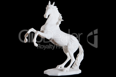 Classic white marble statuette of bucking horse isolated on black background