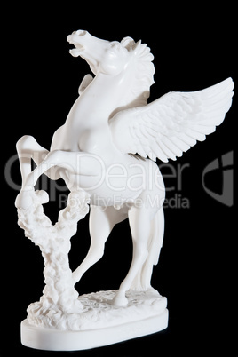 Classic white marble statuette of bucking pegasus isolated on black background
