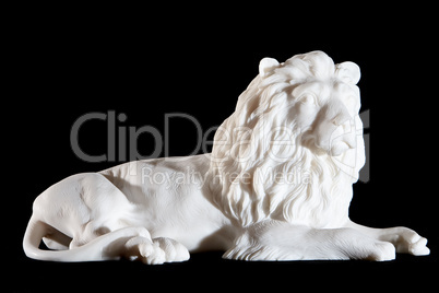 Classic white marble statuette of lying lion isolated on black background