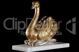 Classic painted gold marble statuette of swan isolated on black background