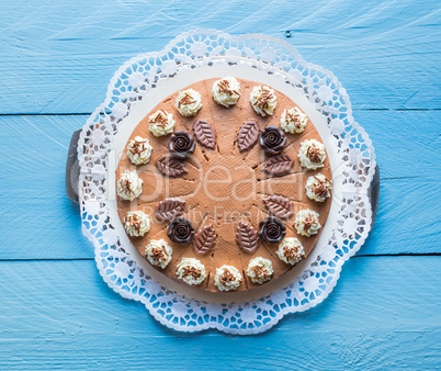 Schokosahnetorte auf blauem Holz mit Tortenspitze