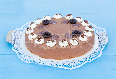 Schokosahnetorte auf blauem Holz mit Tortenspitze