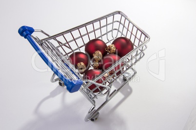 Einkaufswagen mit roten Christbaumkugeln