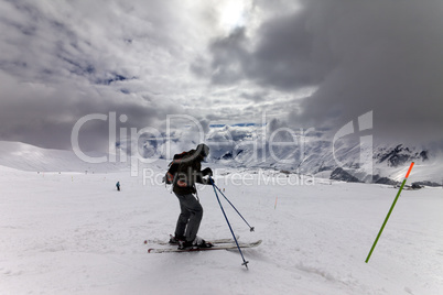 Skier on ski slope before storm