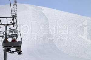 Snowboarders on chair-lift and ski slope