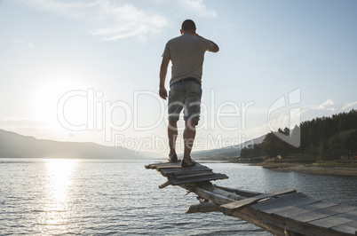 Boy in front of mountain lake