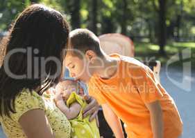 Women, brother and baby in a park.