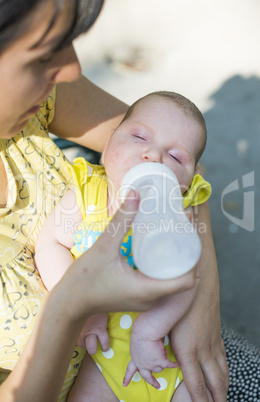 Baby sucks on a bottle