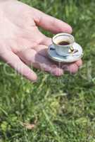 Hand hold very small cup of coffee