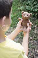 Child hold teddy in the hands