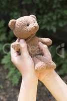 Child hold teddy in the hands