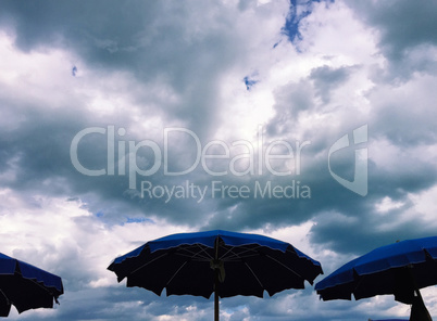 Umbrellas with stormy clouds behind