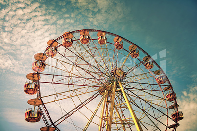 yellow ferris wheel against a blue sky in vintage style