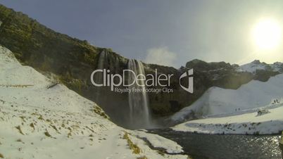 Tourists visiting waterfall Seljalandsfoss in wintertime