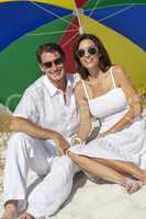 Man & Woman Couple Under Multi Colored Umbrella on Beach