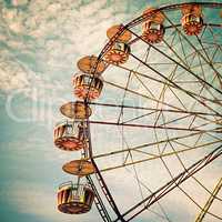 yellow ferris wheel against a blue sky in vintage style