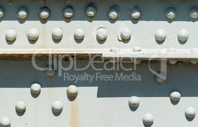 Rivets on painted steel surface with rust stains