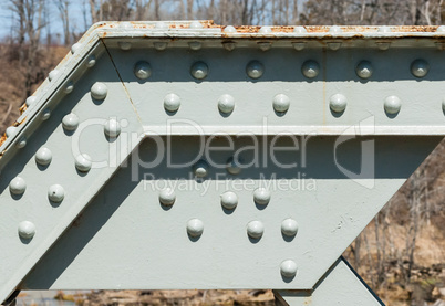 Angled steel girder with rivets on painted surface