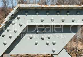 Angled steel girder with rivets on painted surface