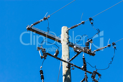Old wood telephone pole with metal bar and insulators