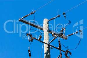 Old wood telephone pole with metal bar and insulators