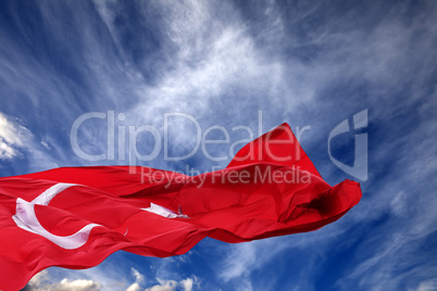 Waving flag of Turkey against blue sky
