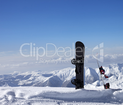 Two snowboards in snow near off-piste slope in sun day