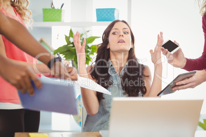 Depressed businesswoman gesturing at desk