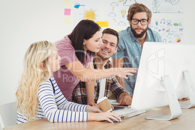 Business professionals discussing at computer desk