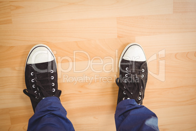 Businessman wearing canvas shoes standing on hardwood floor