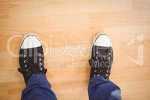 Businessman wearing canvas shoes standing on hardwood floor