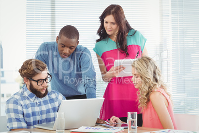 Man discussing with coworkers at desk