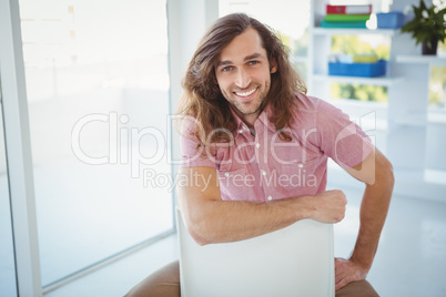 Portrait of hipster smiling while sitting on chair