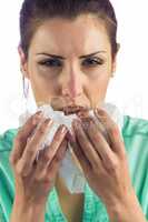 Portrait of sneezing woman holding tissue