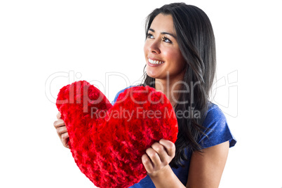 Smiling woman holding a heart shaped pillow