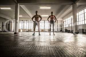 Crossfit couple facing camera with hands on hips
