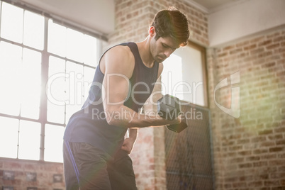 Man in sportswear lifting dumbbell