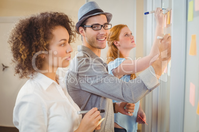 Businessman writing on adhesive notes