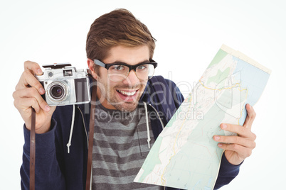 Portrait of happy man holding map and camera